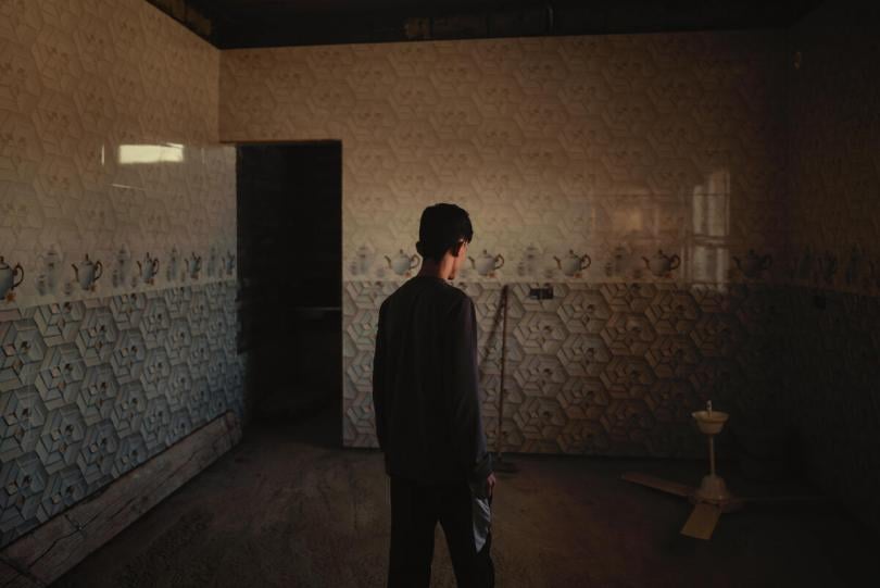 Behat, 17, stands inside his home, Sinjar, northern Iraq.